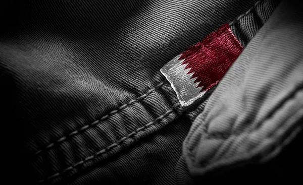 Tag on dark clothing in the form of the flag of the Qatar — Stock Photo, Image