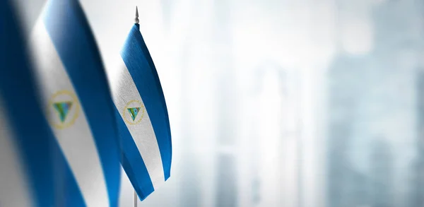 Small flags of Nicaragua on a blurry background of the city — Stock Photo, Image