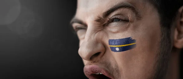 Un hombre gritando con la imagen de la bandera nacional de Nauru en su cara —  Fotos de Stock