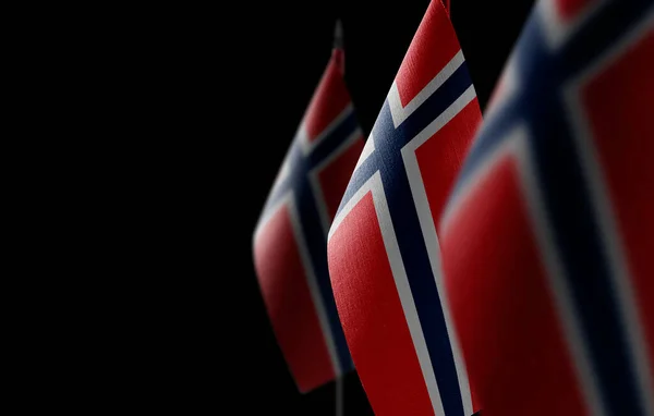 Pequeñas banderas nacionales de Noruega sobre un fondo negro — Foto de Stock