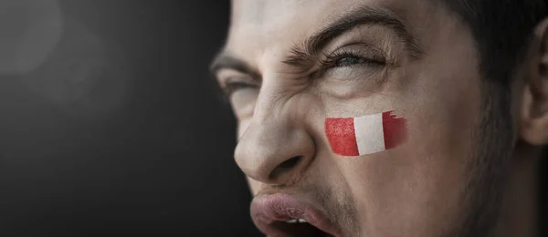 Ein schreiender Mann mit dem Bild der peruanischen Nationalflagge im Gesicht — Stockfoto