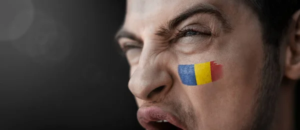 Ένας άνδρας που ουρλιάζει με την εικόνα της εθνικής σημαίας της Ρουμανίας στο πρόσωπό του — Φωτογραφία Αρχείου