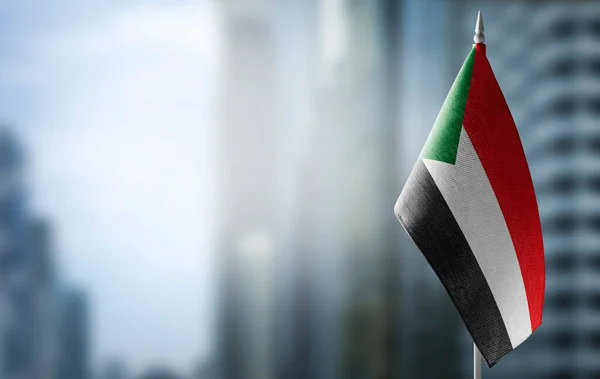 Небольшой флаг Судана на фоне размытого фона — стоковое фото
