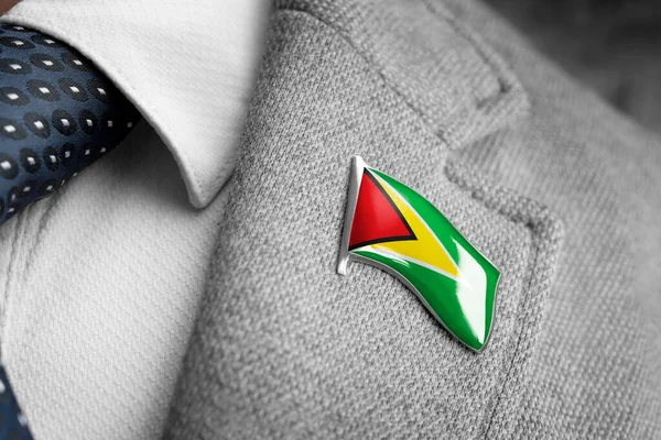 Lencana logam dengan bendera Guyana pada kerah jas — Stok Foto