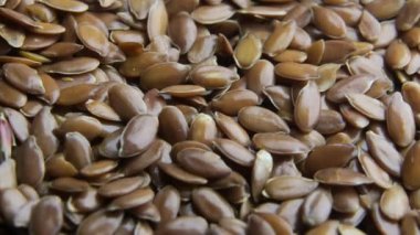 Keten tohumları yavaş çekimde dönen uçtan dökülüyor.