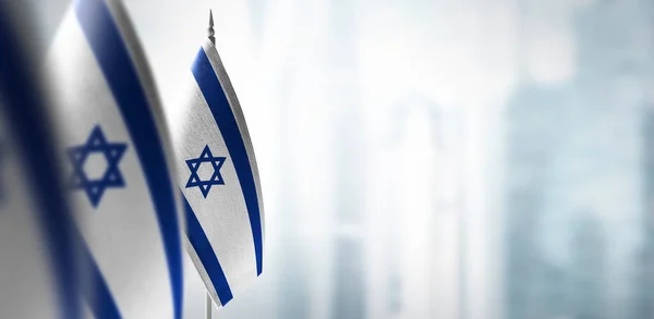 Malé vlajky Izraele na rozmazaném pozadí města — Stock fotografie