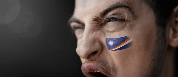 Un hombre gritando con la imagen de la bandera nacional de las Islas Marshall en su cara —  Fotos de Stock