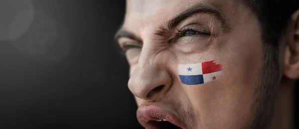 Um homem gritando com a imagem da bandeira nacional do Panamá em seu rosto — Fotografia de Stock