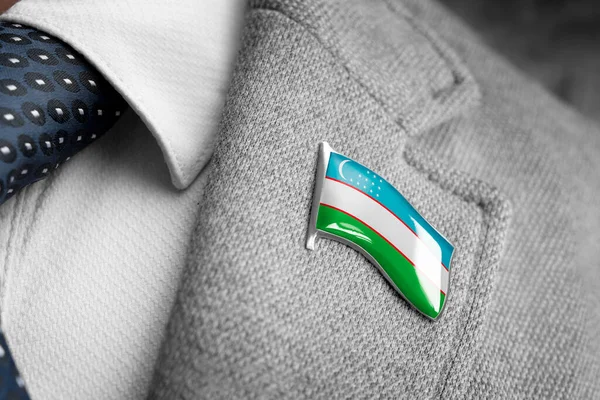 Metal badge with the flag of Uzbekistan on a suit lapel — Stock Photo, Image