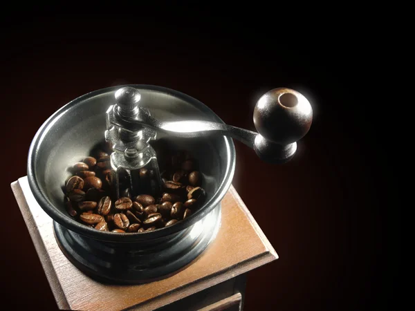 Coffee grinder with grains on a black background — Stock Photo, Image