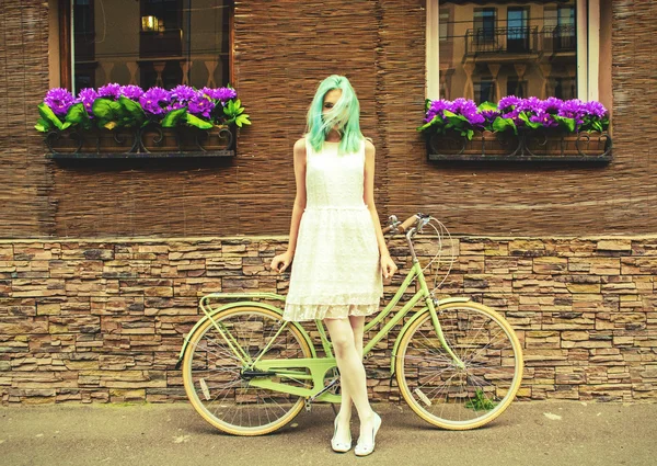 Young girl standing near a bicycle — Stock Photo, Image