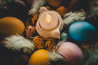 Renkli paskalya yumurtaları ve sepetinde mumlar.