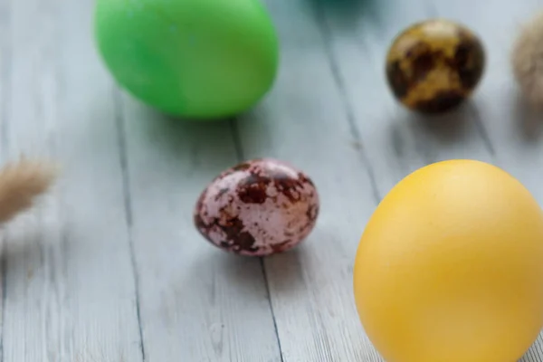 Colored Easter eggs on a light wooden background. Easter holiday with colored eggs