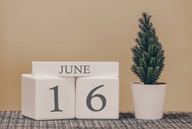 Farklı fikirlerde kullanmak için masa takvimi. Yaz ayı - Haziran ve küplerin numarası 16. Katı bej bir arkaplanda tatil takvimi.