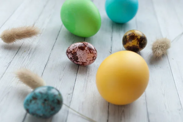 Colored Easter eggs on a light wooden background. Easter holiday with colored eggs