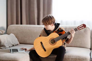 Evde gitar çalan bir çocuk, online ders. Yüksek kaliteli video