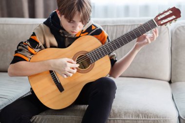 Evde gitar çalan bir çocuk, online ders. Yüksek kaliteli video