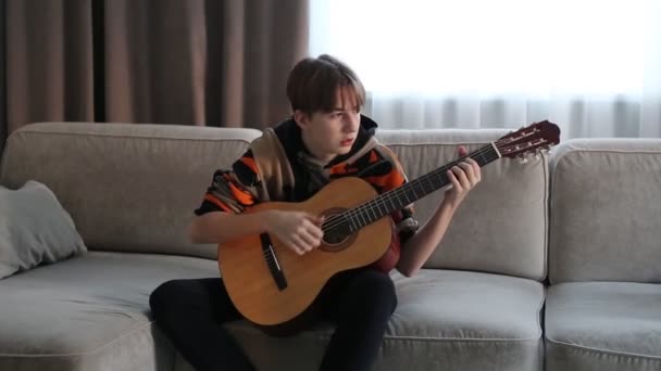 Boy playing guitar at home, online lesson. High quality video — Stock Video