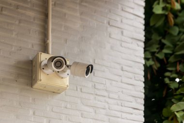 Evin dışındaki güvenlik kamerası güvenlik kamerası sistemi. Bulanık bir gece şehri manzarası. Duvardaki modern CCTV kamerası. Güvenli yaşam ya da varlık için ekipman sistemi hizmeti.