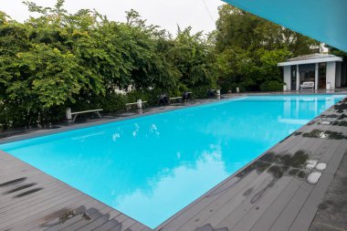 Yüzme havuzu. Yüzme havuzu alt yakıcı dalgalar ve dalgalar arka planda. Lüks otelin yüzme havuzu.