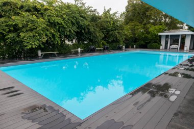 Yüzme havuzu. Yüzme havuzu alt yakıcı dalgalar ve dalgalar arka planda. Lüks otelin yüzme havuzu.