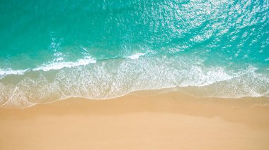 Metnin için fotokopi alanı olan turkuaz suyla çarpıcı güzellikteki deniz manzaralı bir kumsalın insansız hava görüntüsü. Turkuaz suyu ve insansız hava aracı görüntüsü olan güzel bir kumsal.
