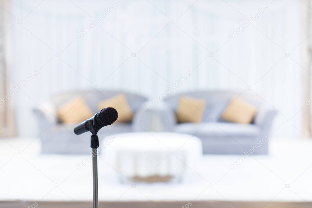 Microphone in concert hall or conference room soft and blur style for background. Microphone over the Abstract blurred photo of conference hall or seminar room background.