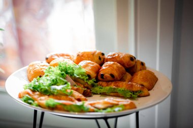 Lokanta büfesi yemek masasında çikolatalı çörek. Yemek masasında leziz yemekler var. Düğünde bir yığın kruvasan sandviçi