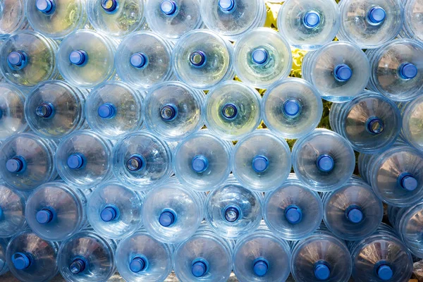 Plastic water bottle background, blue bottle caps, orderly arrangement. Empty bottles for drinking water. Heap of empty plastic drinking water bottles. clear bottles when poured out of water. — Stock Image Plastic Water Bottle Background Blue Bottle Caps Orderly Arrangement Empty Stock Picture