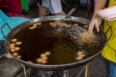 Şef Çin ziyafeti hazırlamak için büyük tavada karides pişiriyor. Yağ aktarma konseptinden yağ. Kolesterol ve Trans-yağ konsepti hastalığı.