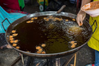 Şef Çin ziyafeti hazırlamak için büyük tavada karides pişiriyor. Yağ aktarma konseptinden yağ. Kolesterol ve Trans-yağ konsepti hastalığı.