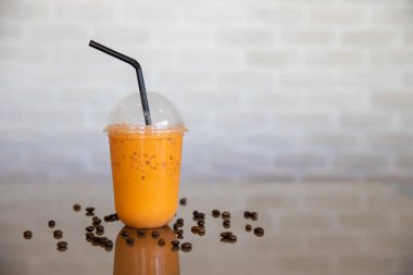 Paket servis bardağında buzlu Tayland çayı. Taze Tayland çaylı bir bardak Thai çayı. Ev yapımı sütlü buzlu latte çayı..