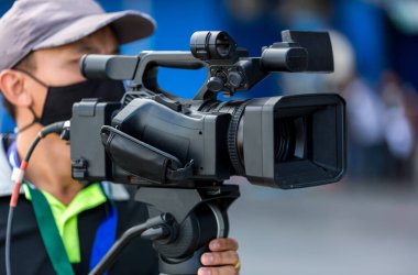 Video kamera operatörü ekipmanlarıyla çalışıyor. Video sinema yapımı. Bir olayı video kamerayla görüntülemek. Profesyonel video adam kamera operatörü kamerasıyla çalışıyor..