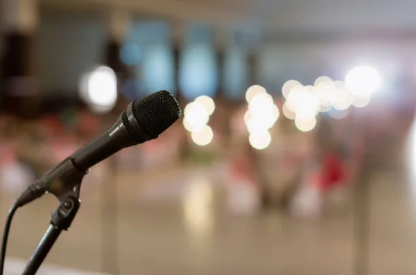 Microphone in concert hall or conference room soft and blur style for background. Microphone over the Abstract blurred photo of conference hall or seminar room background.