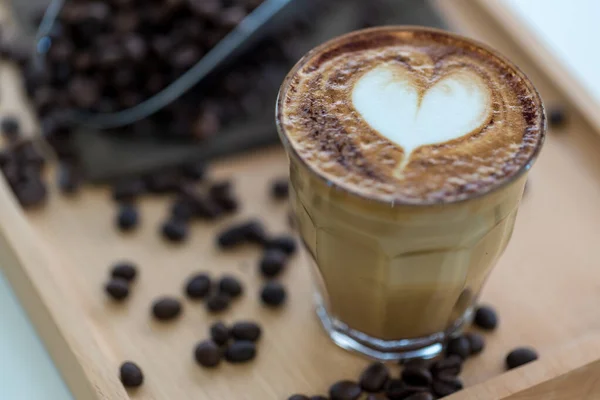 Coffee Latte Art. The coffee arts. Hot coffee in a white cup on wooden table. Hot chocolate Nutella latte art on wood table.