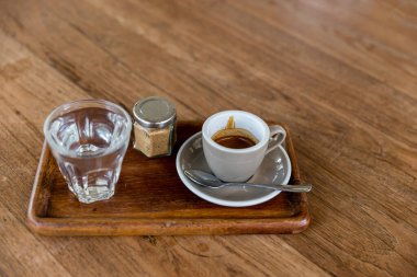 Cam bardakta koyu kahve. Bir fincan espresso kahvesi. Gri ahşap masada ya da masada bir fincan koyu kahve..