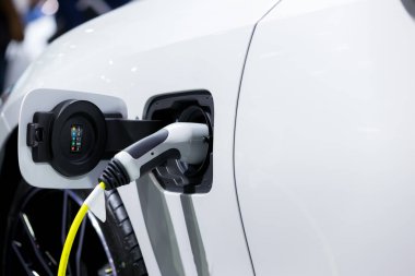 Elektrikli araba şarj istasyonu. Otoparktaki hibrit araba elektrik şarj istasyonu. Elektrikli araba park ve şarj istasyonunda şarj oluyor. Elektrik prizi. Ulaşım EV