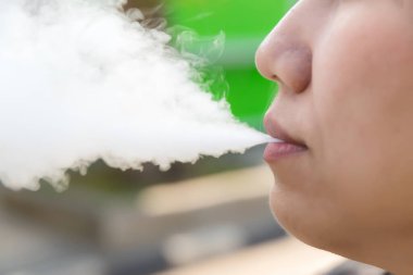 Sigara içiyorum. Kadın e-sigara içiyor. Göz kamaştırıcı bir sigara..