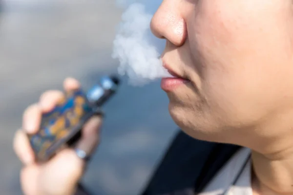 smoking a cigarette smoke. woman smoking an e-cigarette. Glamorous smoke electronic cigarette.