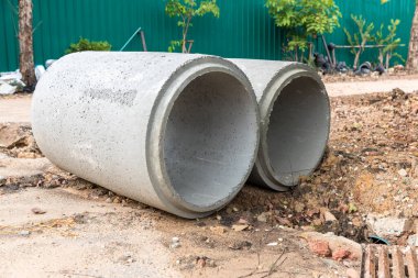 İnşaat alanındaki beton drenaj borusu. İnşaat için yığılmış beton drenaj boruları. Ana yolun yakınındaki inşaat alanında beton drenaj borusu.