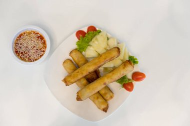 Kırmızı ve beyaz soslu kızarmış börek. Beyaz tabakta soslu kızarmış börek. Sebzeli gevrek börek. Kızarmış Çin Geleneksel Bahar Yemeği.