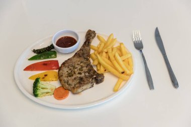 Izgara et, domuz pirzolası, biber soslu biftek ve salata. Kızarmış domuz pirzolası, sebze ve gömme sosu. Şef dekore edilmiş domuz pirzolası..