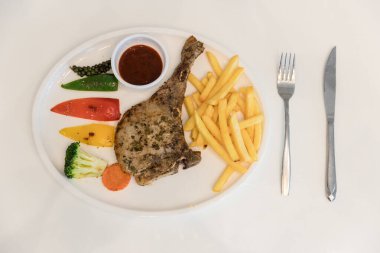 Izgara et, domuz pirzolası, biber soslu biftek ve salata. Kızarmış domuz pirzolası, sebze ve gömme sosu. Şef dekore edilmiş domuz pirzolası..