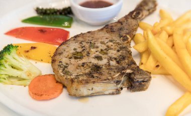 Izgara et, domuz pirzolası, biber soslu biftek ve salata. Kızarmış domuz pirzolası, sebze ve gömme sosu. Şef dekore edilmiş domuz pirzolası..