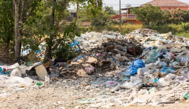 Ev içi çöp yığını. Bir sürü plastik torba, şişe ve diğer atıklarla dolu bir çöp yığını. Sokakta bir sürü çöp var..