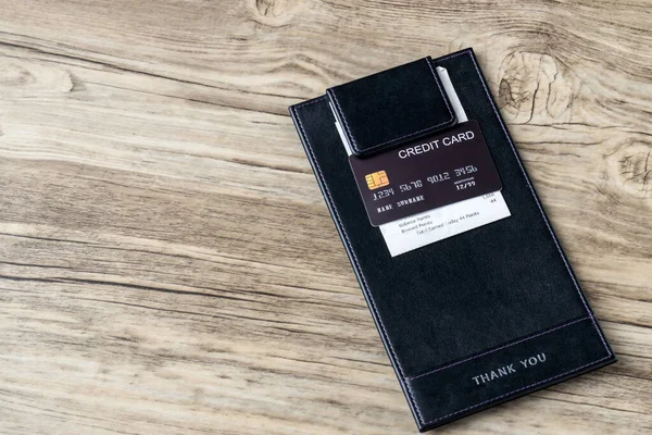 空白票据上的黑色信用卡为皮革黑色票据收据 咖啡店或餐馆的信用卡收据持有者 — 图库照片