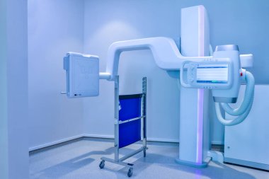 Modern hastanede röntgen cihazları var. Modern X-ray makinesi ve hastanede Axial Tomografi taraması. Hastanenin ameliyat odasındaki röntgen odası. Klasik tavana monte edilmiş röntgen cihazı.