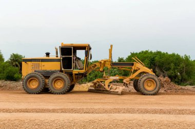 Grader Road Construction Grader endüstriyel makinesi yeni yollar inşa ediyor. Kumlu bir yol temelini yıkma sürecinde olan bir motorcunun bıçağı. Grader yol inşaatında çalışıyor..