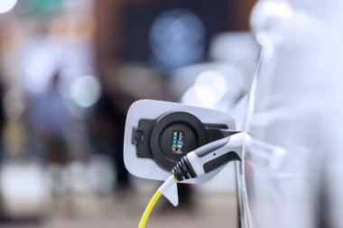 Elektrikli araba şarj istasyonu. Otoparktaki hibrit araba elektrik şarj istasyonu. Elektrikli araba park ve şarj istasyonunda şarj oluyor. Elektrik prizi. Ulaşım EV