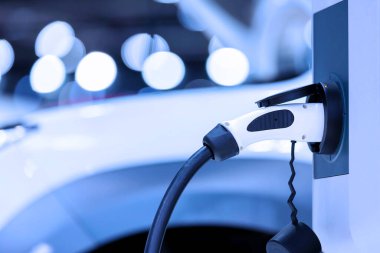 Elektrikli araba şarj istasyonu. Otoparktaki hibrit araba elektrik şarj istasyonu. Elektrikli araba park ve şarj istasyonunda şarj oluyor. Elektrik prizi. Ulaşım EV